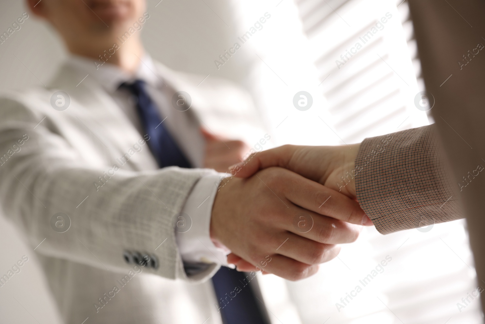 Photo of Business people shaking hands in office, closeup