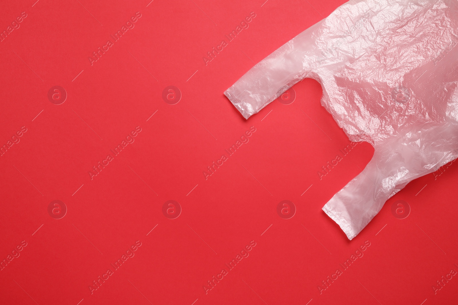 Photo of One plastic bag on red background, top view. Space for text