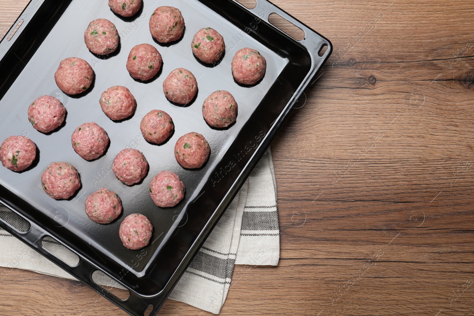 Photo of Many fresh raw meatballs on wooden table, top view. Space for text