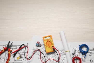 Photo of Flat lay composition with wiring diagrams and digital multimeter on white wooden table, space for text