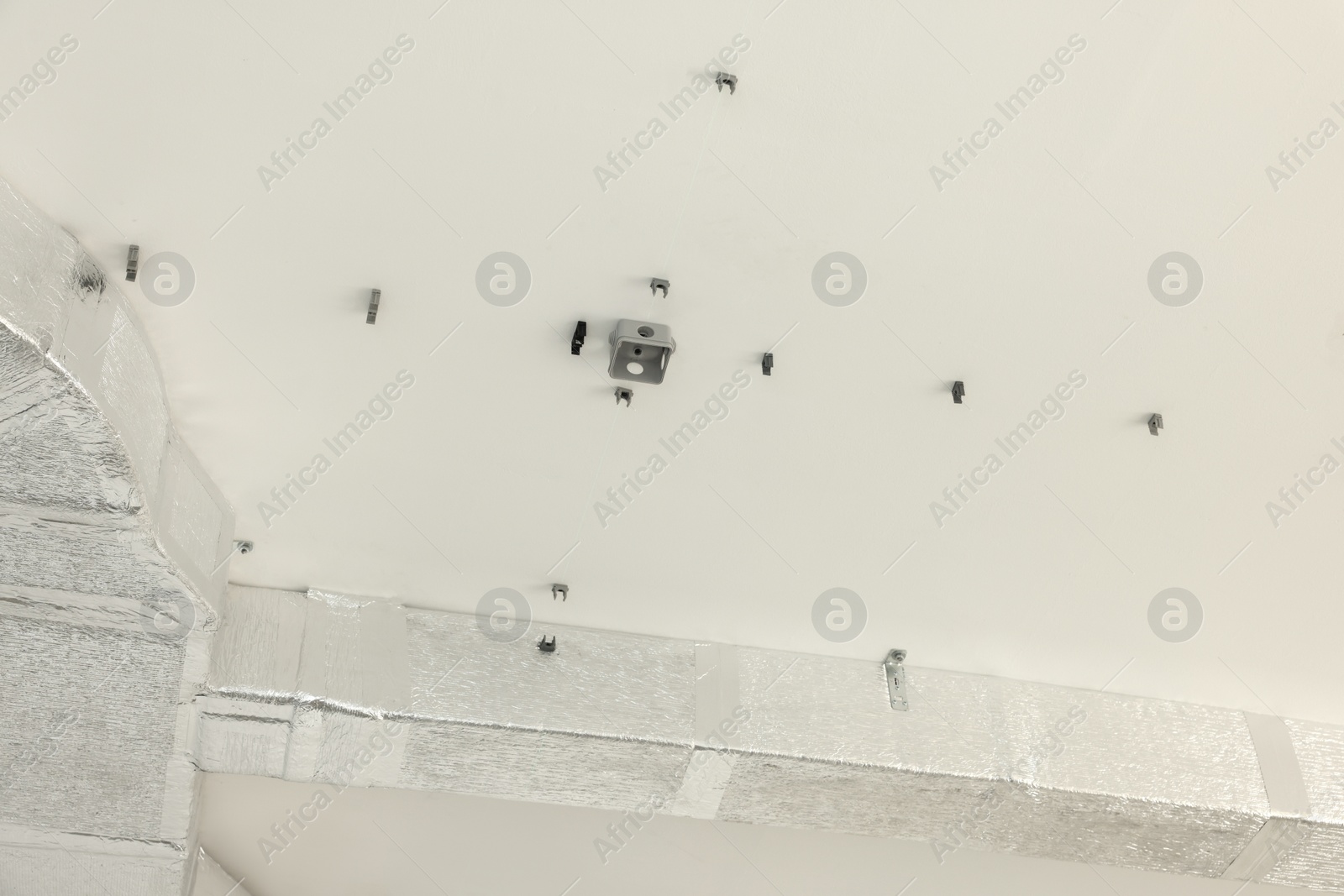 Photo of Connectors for wires and ventilation system on ceiling indoors