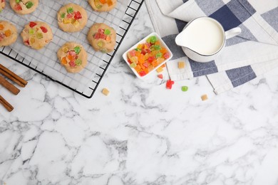 Photo of Unbaked cookies with candied fruits on white marble table, flat lay. Space for text