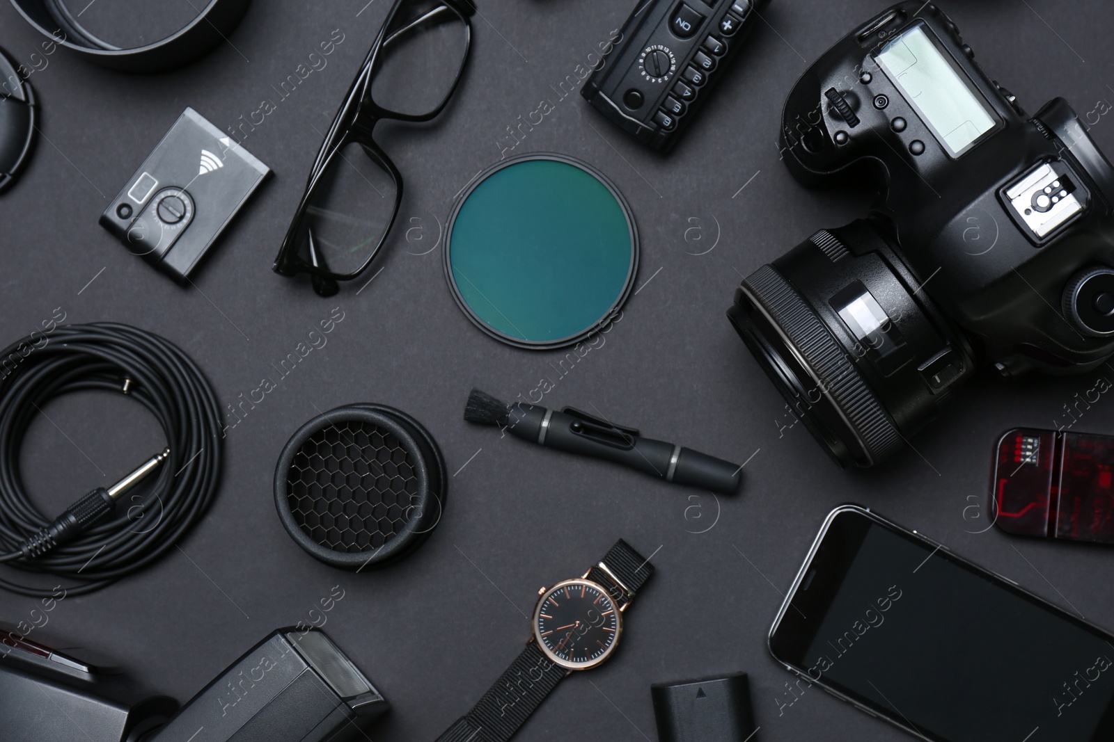 Photo of Flat lay composition with equipment for professional photographer on dark background