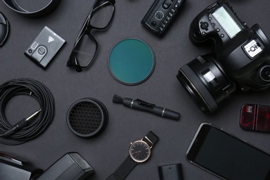 Flat lay composition with equipment for professional photographer on dark background