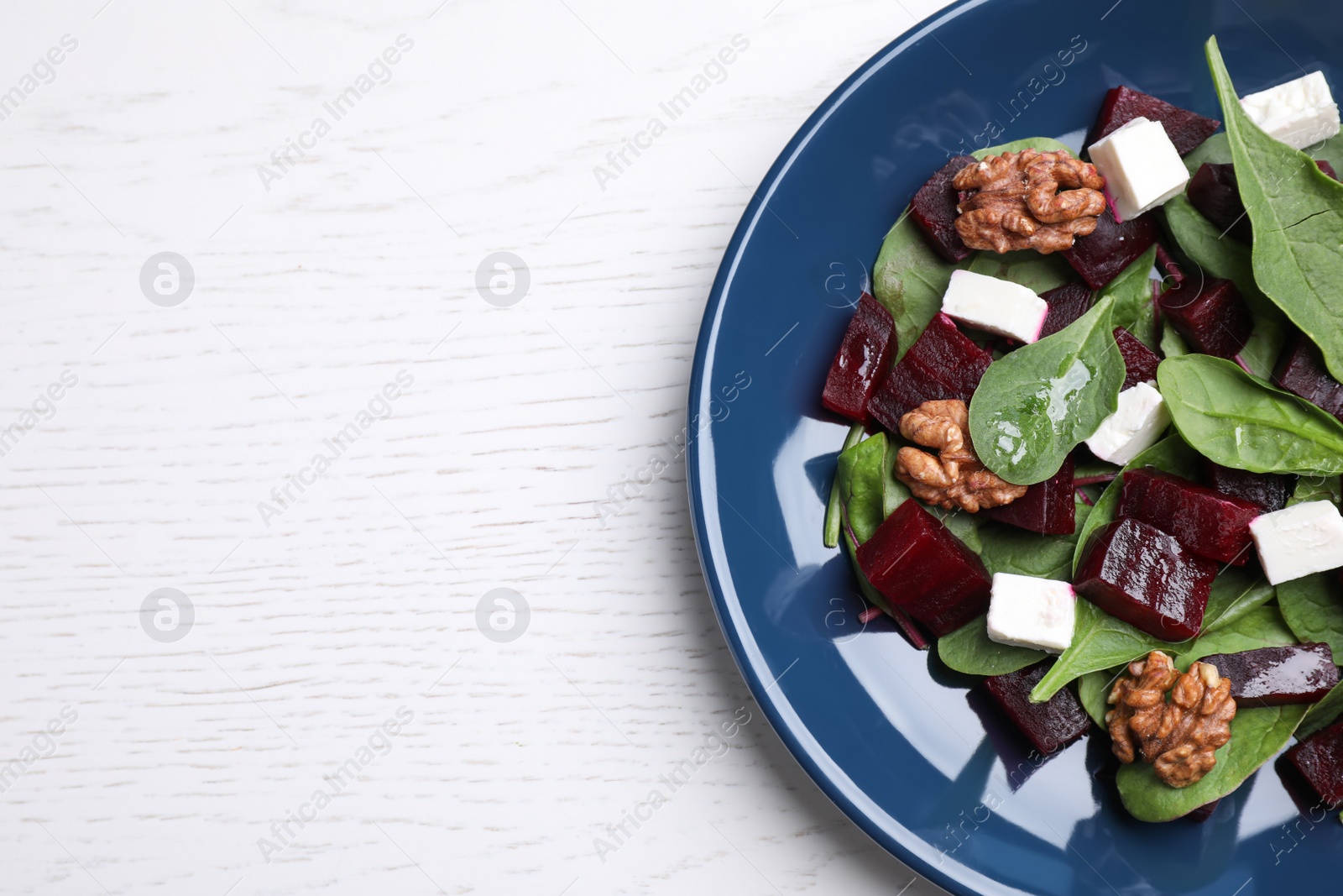 Photo of Fresh delicious beet salad on white wooden table, top view. Space for text