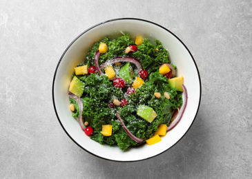 Tasty fresh kale salad on light grey table, top view