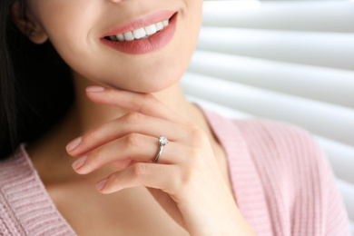 Photo of Young woman wearing beautiful engagement ring, closeup