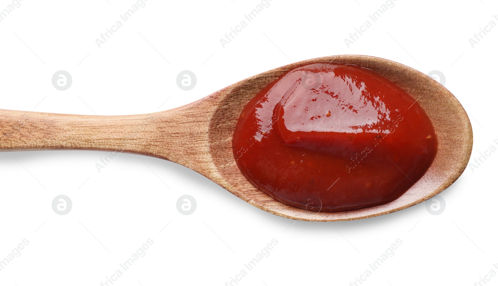 Photo of Tasty ketchup in wooden spoon on white background, top view