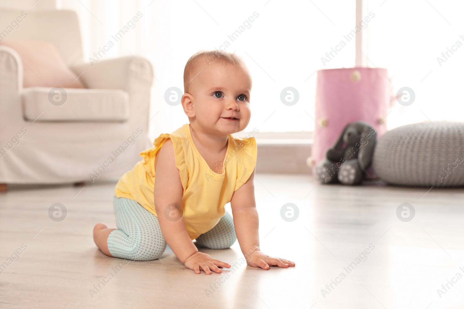 Photo of Cute baby girl on floor in room