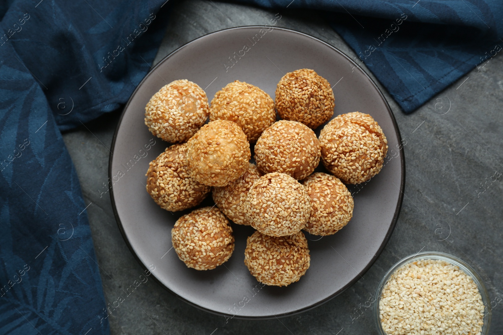 Photo of Delicious sesame balls on grey table, flat lay
