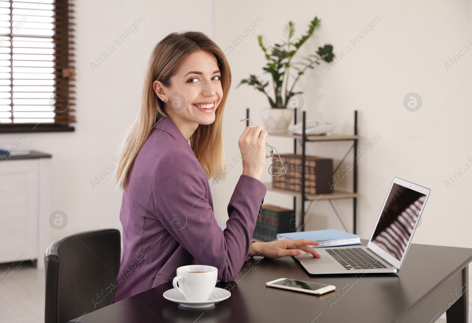 Image of Young woman working on laptop in office