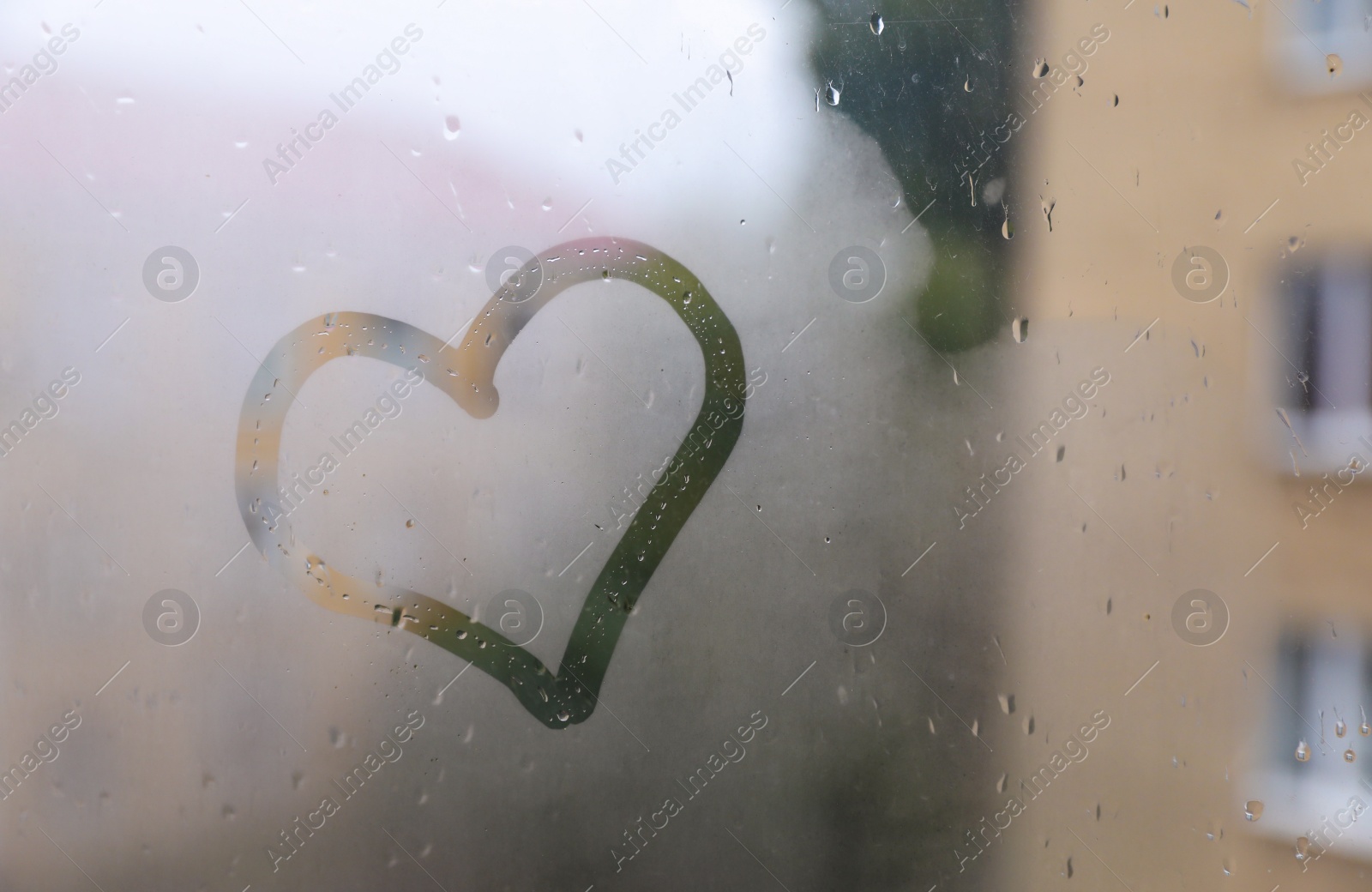 Photo of Heart drawn on foggy window. Rainy weather