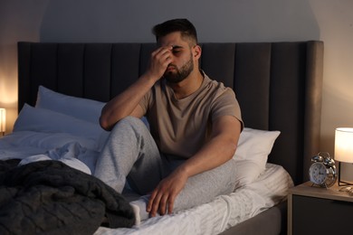 Photo of Man suffering from insomnia on bed at home