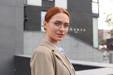 Portrait of beautiful woman in glasses outdoors, space for text