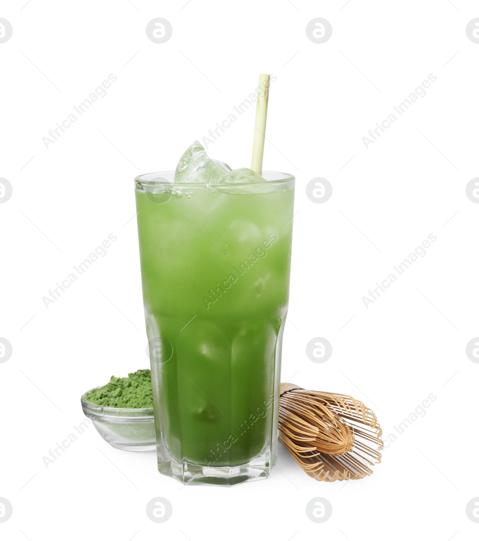 Photo of Glass of delicious iced green matcha tea, powder and bamboo whisk isolated on white