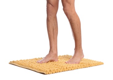 Man standing on soft yellow bath mat against white background, closeup