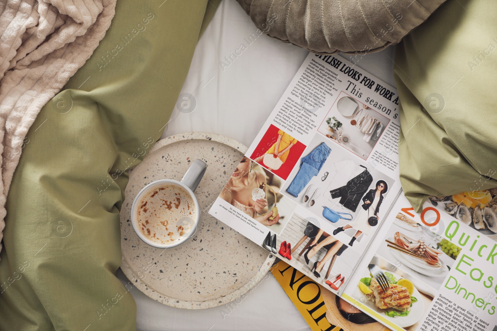 Photo of Aromatic coffee and magazines on bed with linens indoors, flat lay