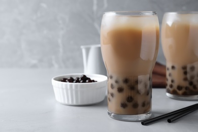 Photo of Bubble milk tea with tapioca balls on light table. Space for text