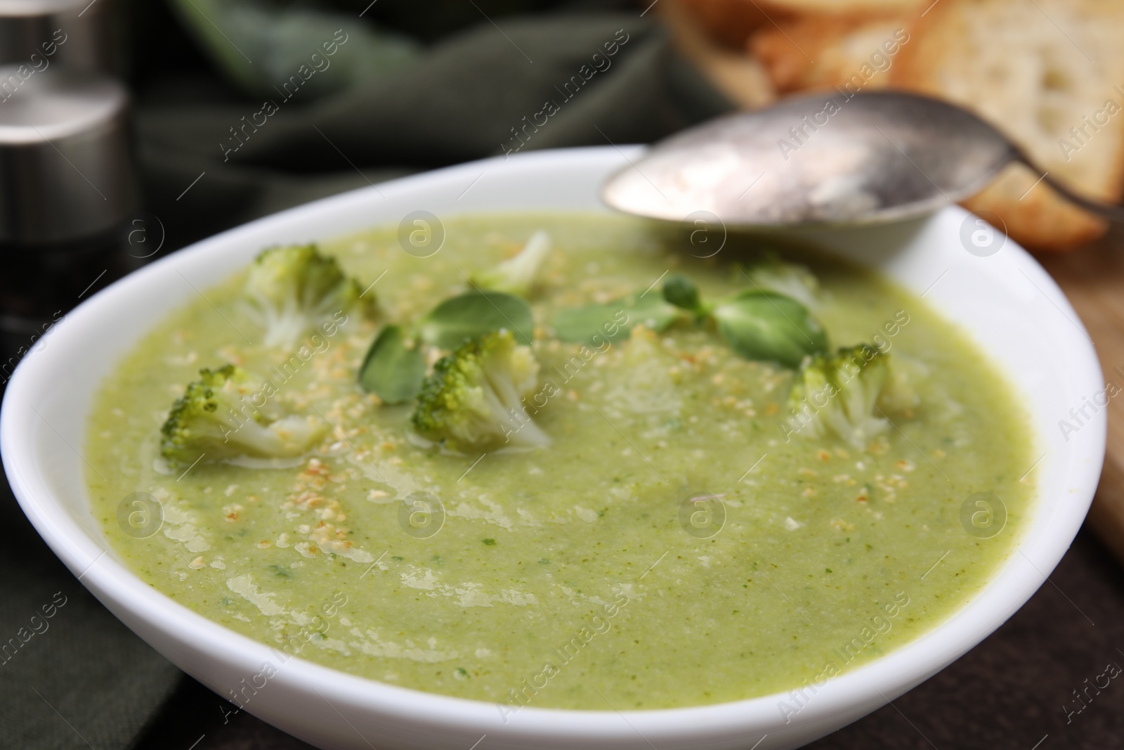 Photo of Delicious broccoli cream soup served on table, closeup