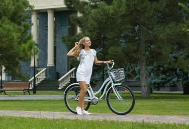 Beautiful woman in casual outfit with bicycle on city street