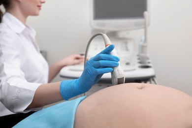 Pregnant woman undergoing ultrasound scan in clinic, closeup