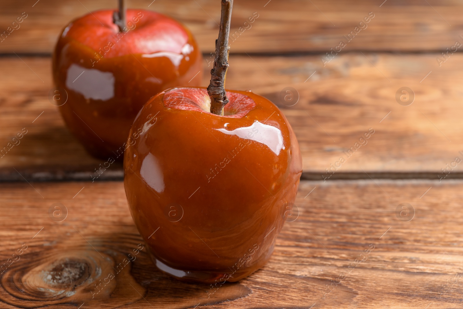 Photo of Delicious red caramel apples on table