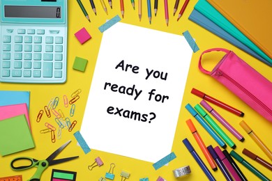 Photo of Paper with phrase Are You Ready For Exams and stationery on yellow background, flat lay