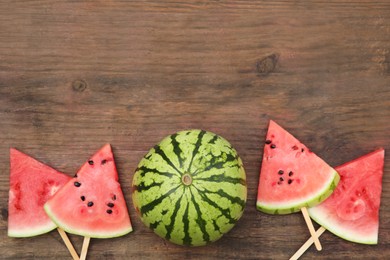 Photo of Whole and sliced delicious ripe watermelon on wooden table, flat lay