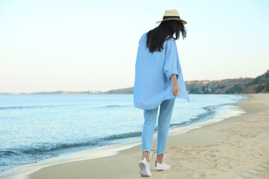 Photo of Beautiful young woman in casual outfit on beach