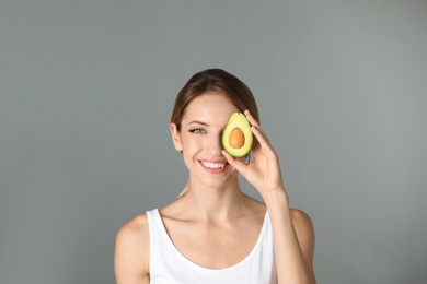 Photo of Portrait of young beautiful woman with ripe delicious avocado on color background