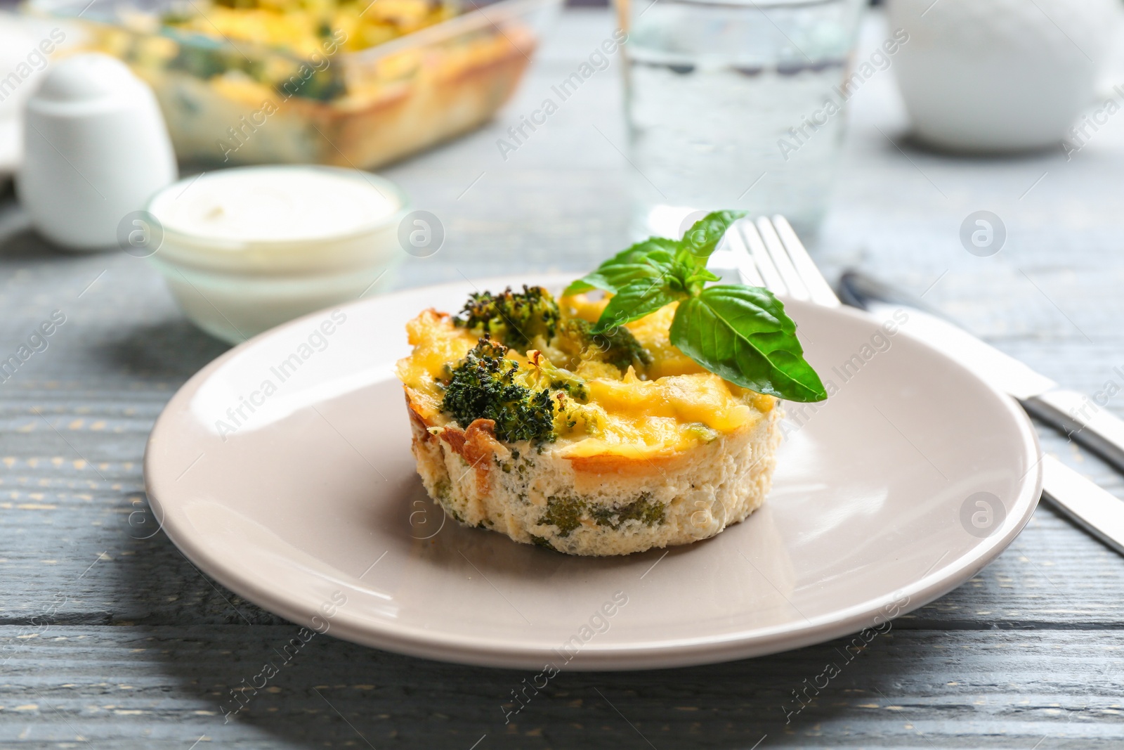 Photo of Tasty broccoli casserole served on wooden table