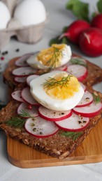 Tasty sandwiches with boiled egg and radish on white table, closeup