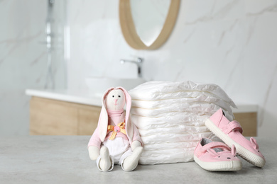 Stack of diapers and baby accessories on counter in bathroom