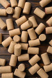 Many corks of wine bottles on wooden table, flat lay