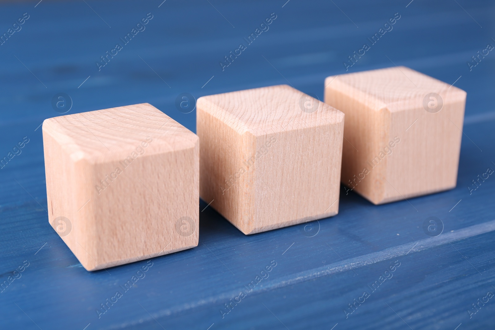 Photo of International Organization for Standardization. Cubes with abbreviation ISO on blue wooden table, closeup