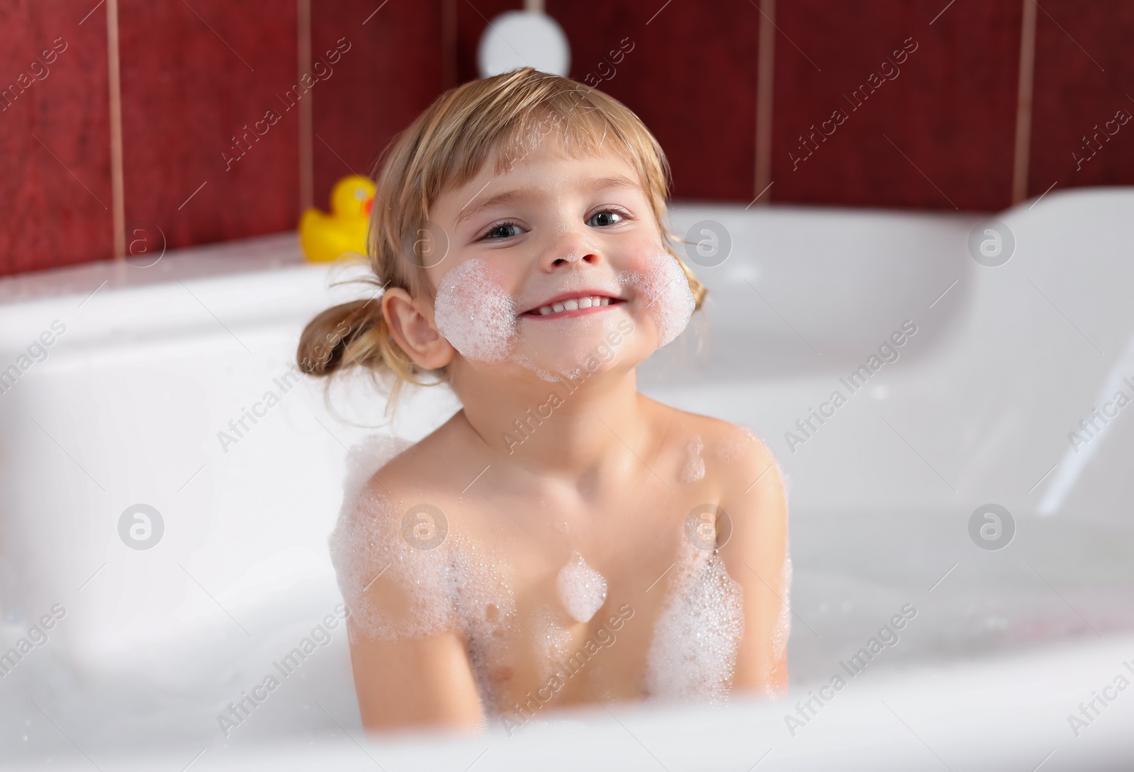 Photo of Happy girl bathing in tub at home