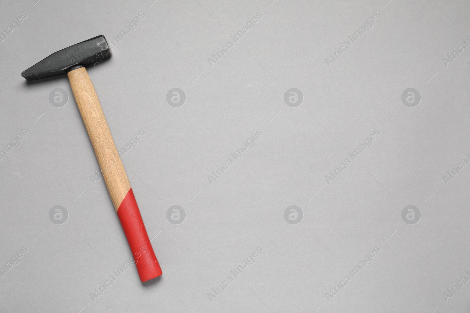 Photo of New hammer with wooden handle on grey background, top view. Space for text