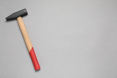 New hammer with wooden handle on grey background, top view. Space for text