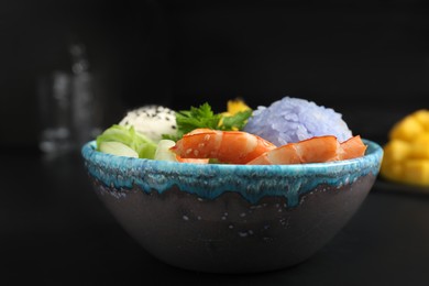 Delicious poke bowl served on black table, closeup