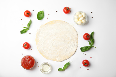 Flat lay composition with dough and fresh ingredients for pizza on white background