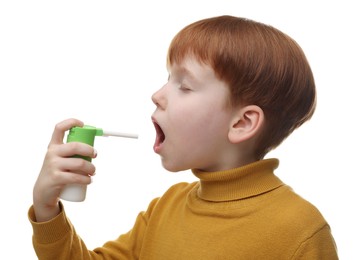 Little boy using throat spray on white background