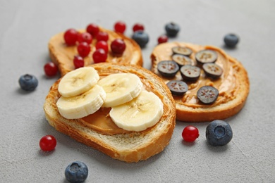 Photo of Slices of bread with different toppings on grey table