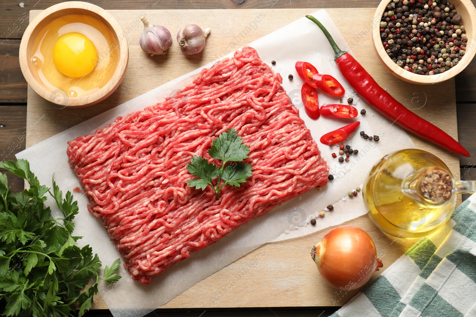 Photo of Raw ground meat and different products on wooden table, flat lay