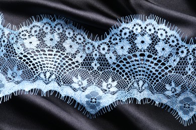 Photo of Light blue lace on black fabric, top view