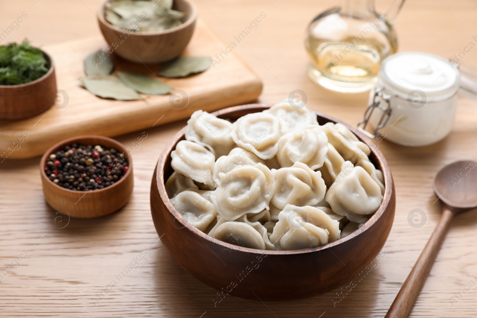 Photo of Tasty dumplings in bowl served on wooden table