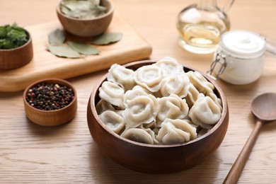 Tasty dumplings in bowl served on wooden table