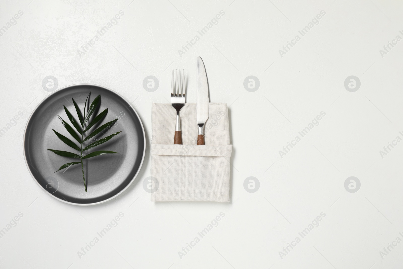 Photo of Stylish setting with elegant cutlery on white table, top view. Space for text