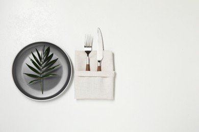 Stylish setting with elegant cutlery on white table, top view. Space for text