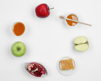 Photo of Honey, apples and pomegranate on white background, top view with space for text. Rosh Hashanah holiday