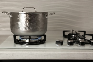 Shiny steel saucepan on modern gas stove. Space for text